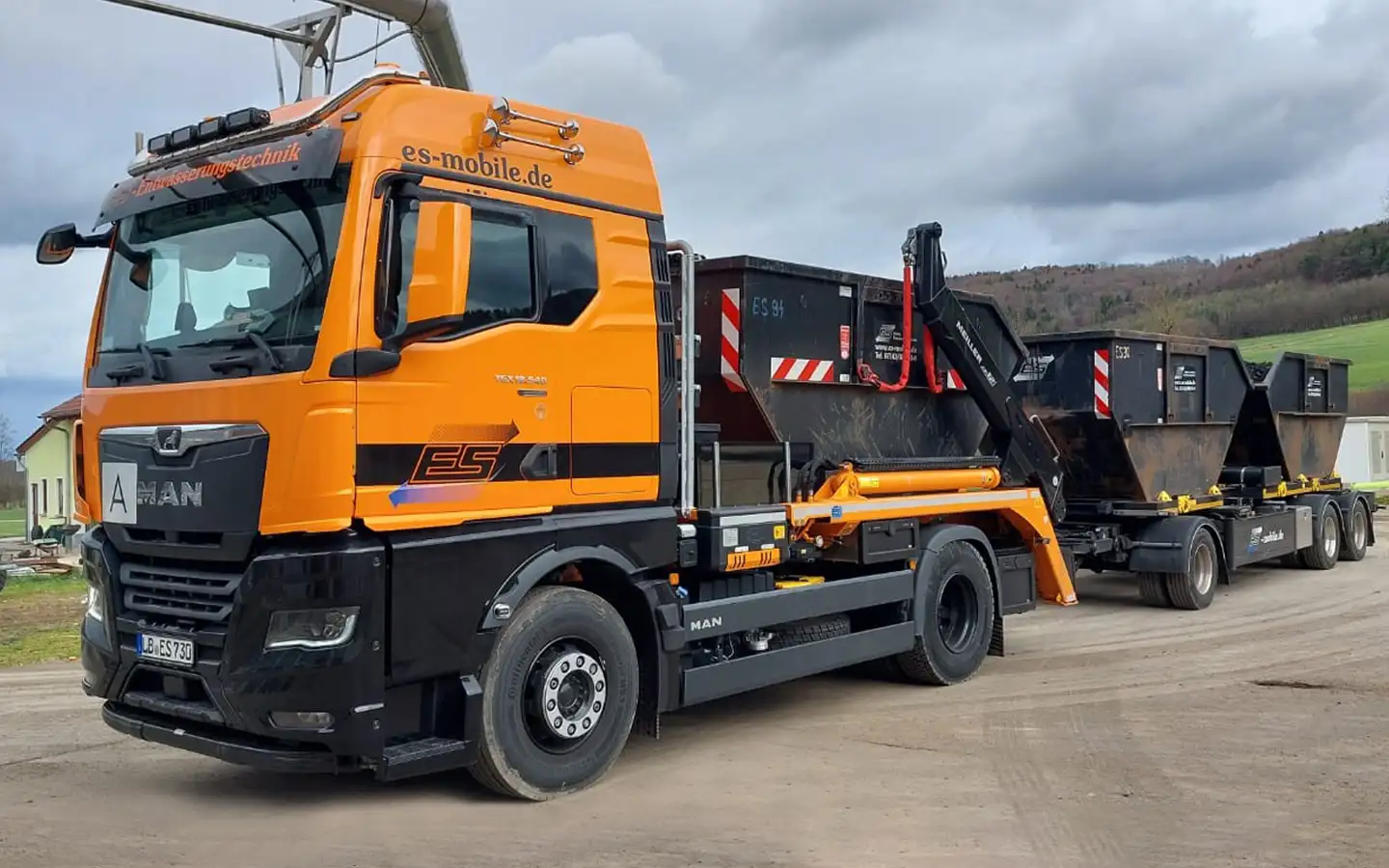 Lkw-Absetzkipper von ES Mobile mit Containeranhänger und drei Absetzmulden